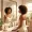 Woman with medium-brown skin looking calmly at her reflection in morning light